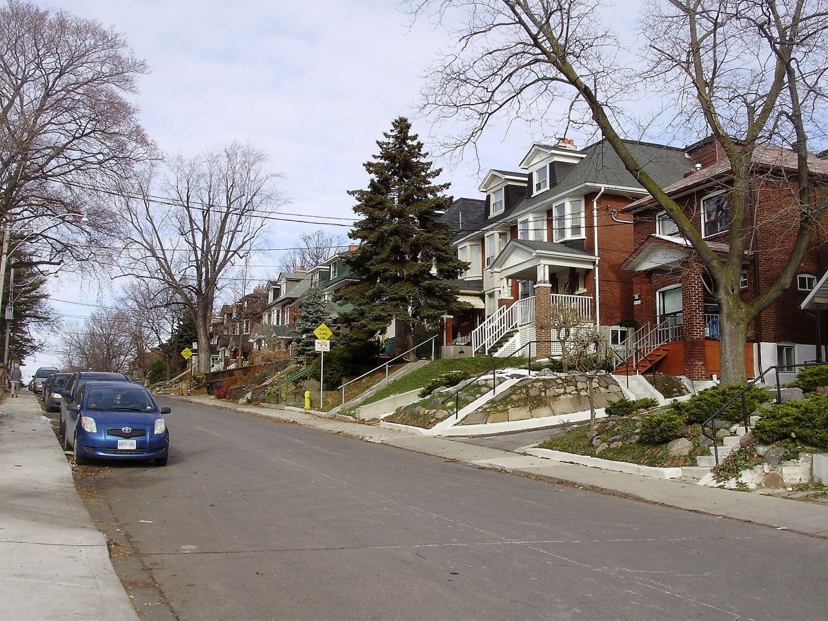 Street of brick homes with front porches in Wychwood, Toronto